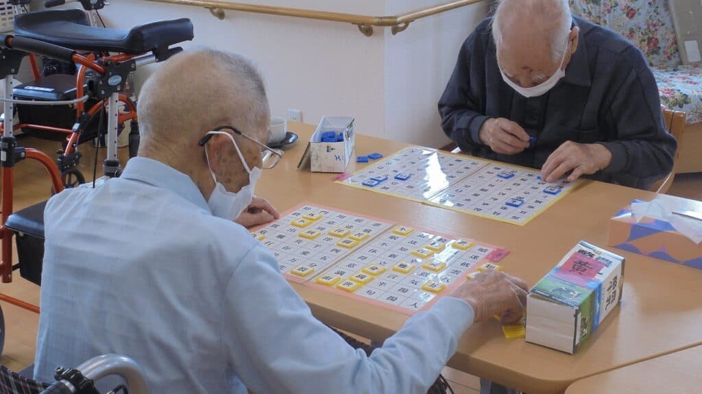 高齢者が数字盤を使ったレクリエーション活動に参加している様子