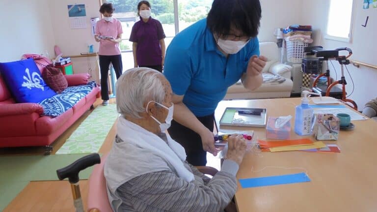 介護職員が高齢者にリハビリ・活動支援を行う共用スペースでの実際の風景